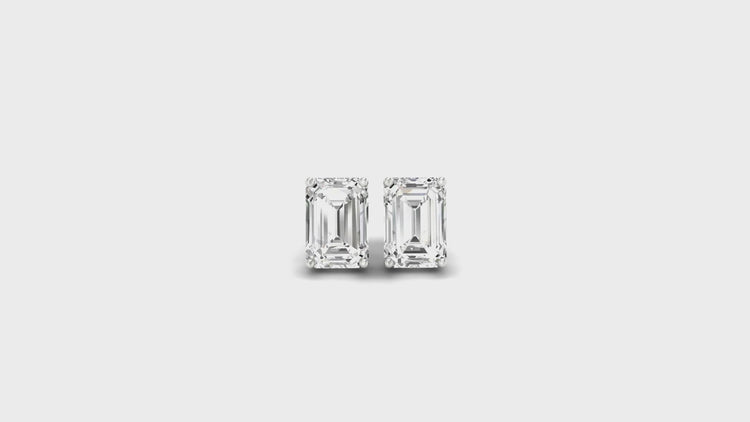Emerald cut diamond stud earrings in white gold with secure screw back design.
