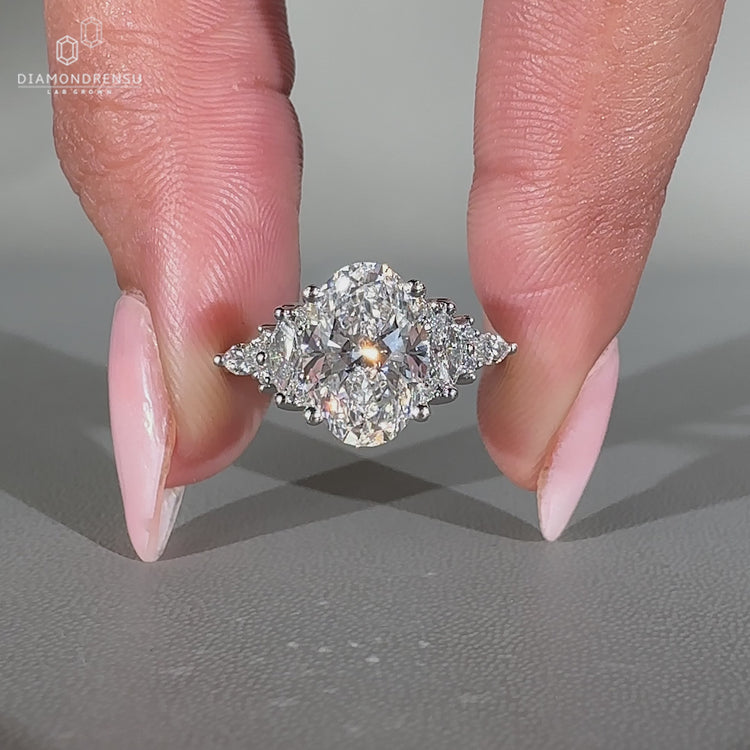Oval engagement ring with round and marquise cluster setting.