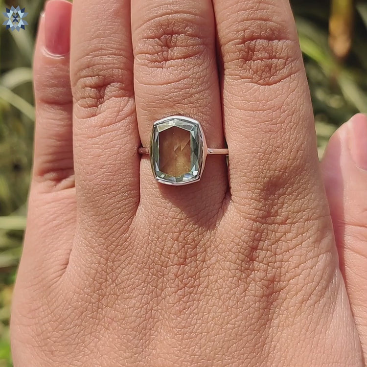 Custom solitaire ring featuring bezel set cyan cushion moissanite.
