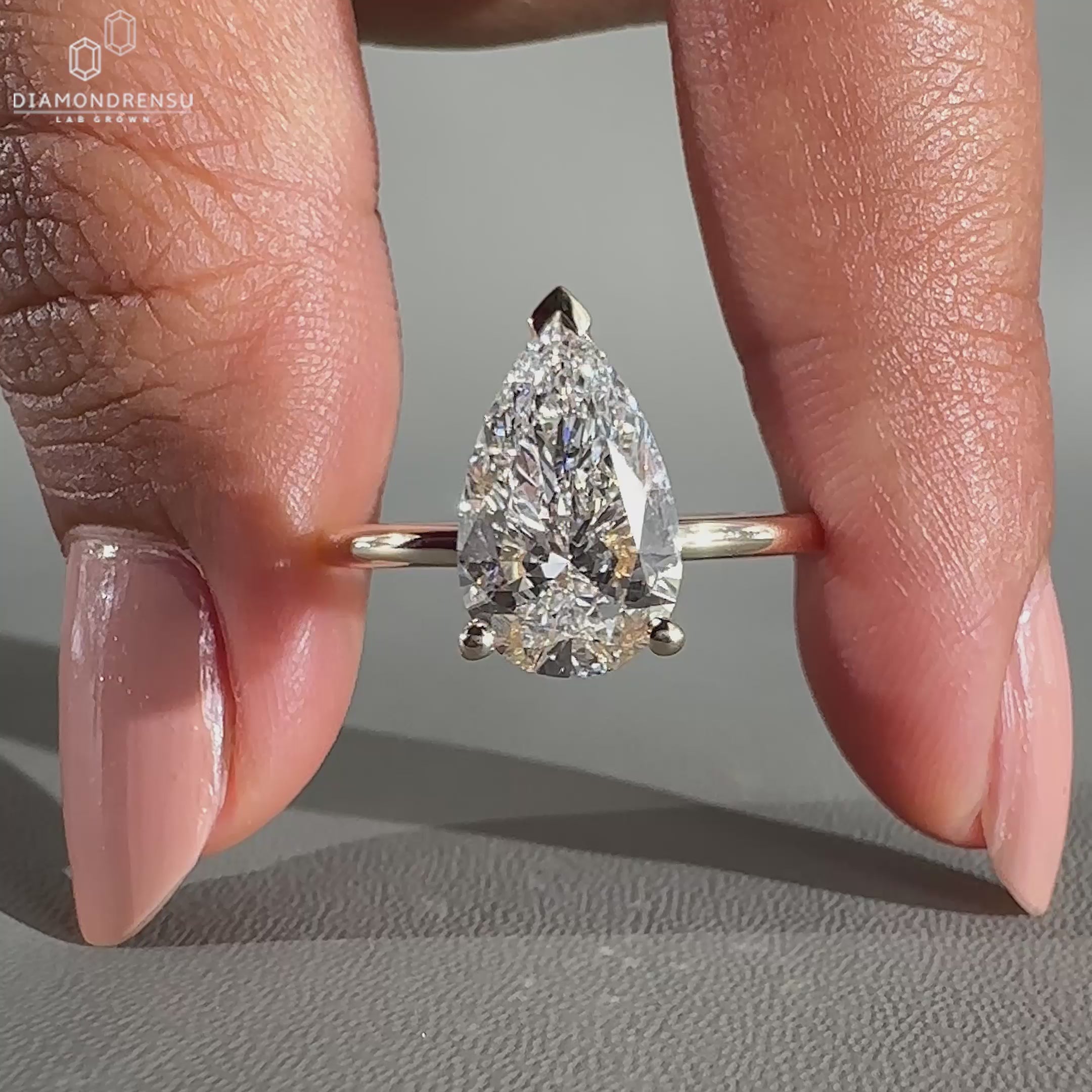 Yellow gold ring with pear shaped center diamond.
