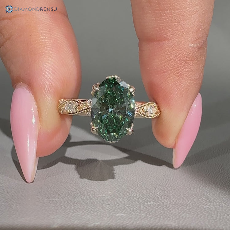 Oval diamond ring with marquise side stones and milgrain.