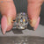 Cushion OMC diamond ring with cathedral setting.