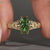 Green centre diamond ring with split shank design.