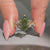 Green centre diamond ring with round marquise side stones.