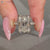 Radiant cut ring with hidden halo and round diamonds.