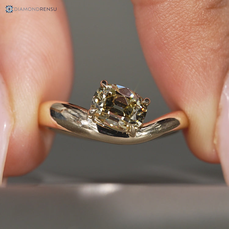 Yellow cushion OMC diamond ring with east to west setting.