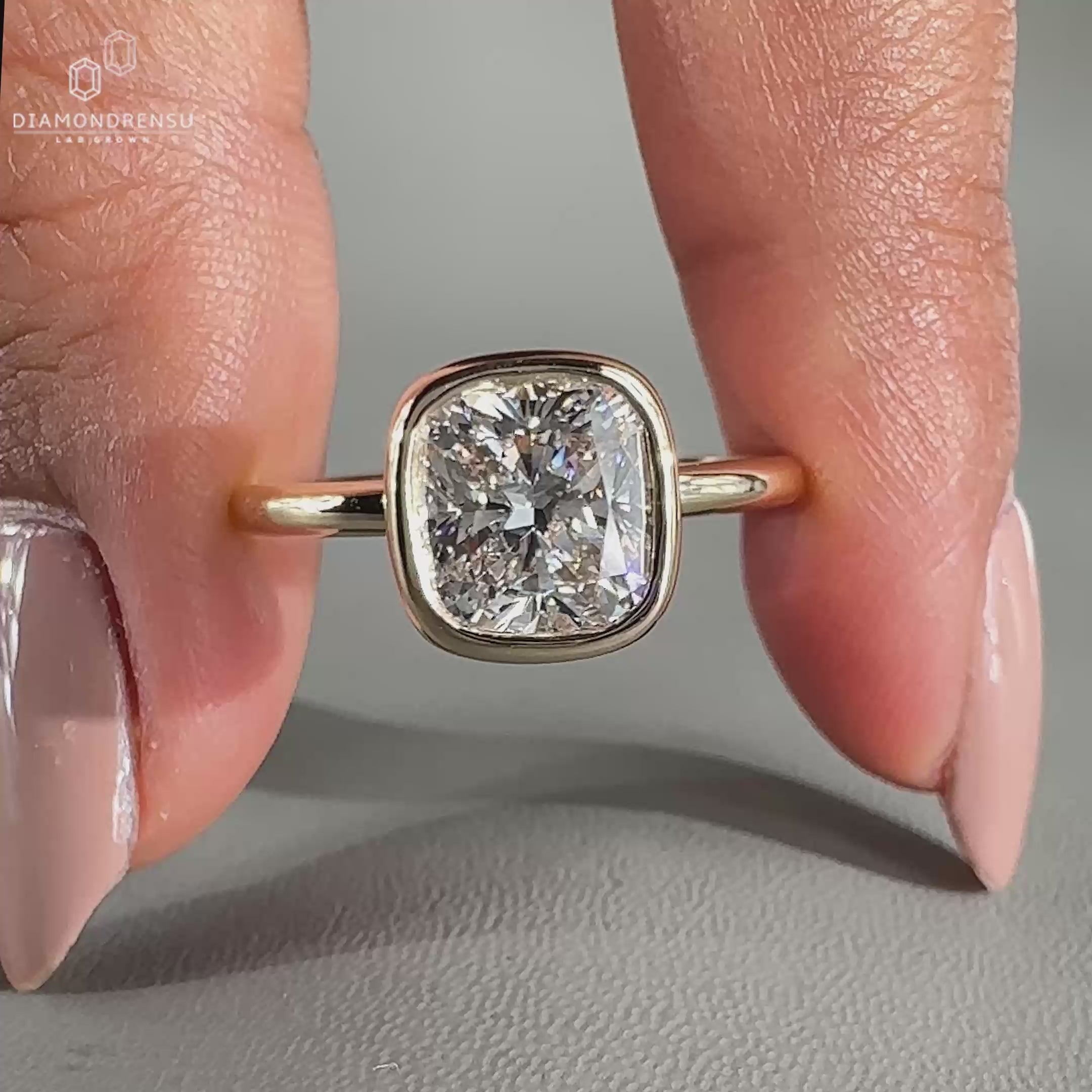 This bezel set engagement ring includes one cushion cut diamond in a secure setting.
