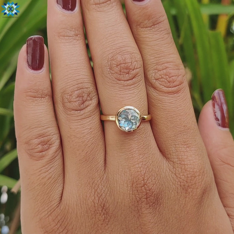 Aqua blue green moissanite set in yellow gold solitaire ring.
