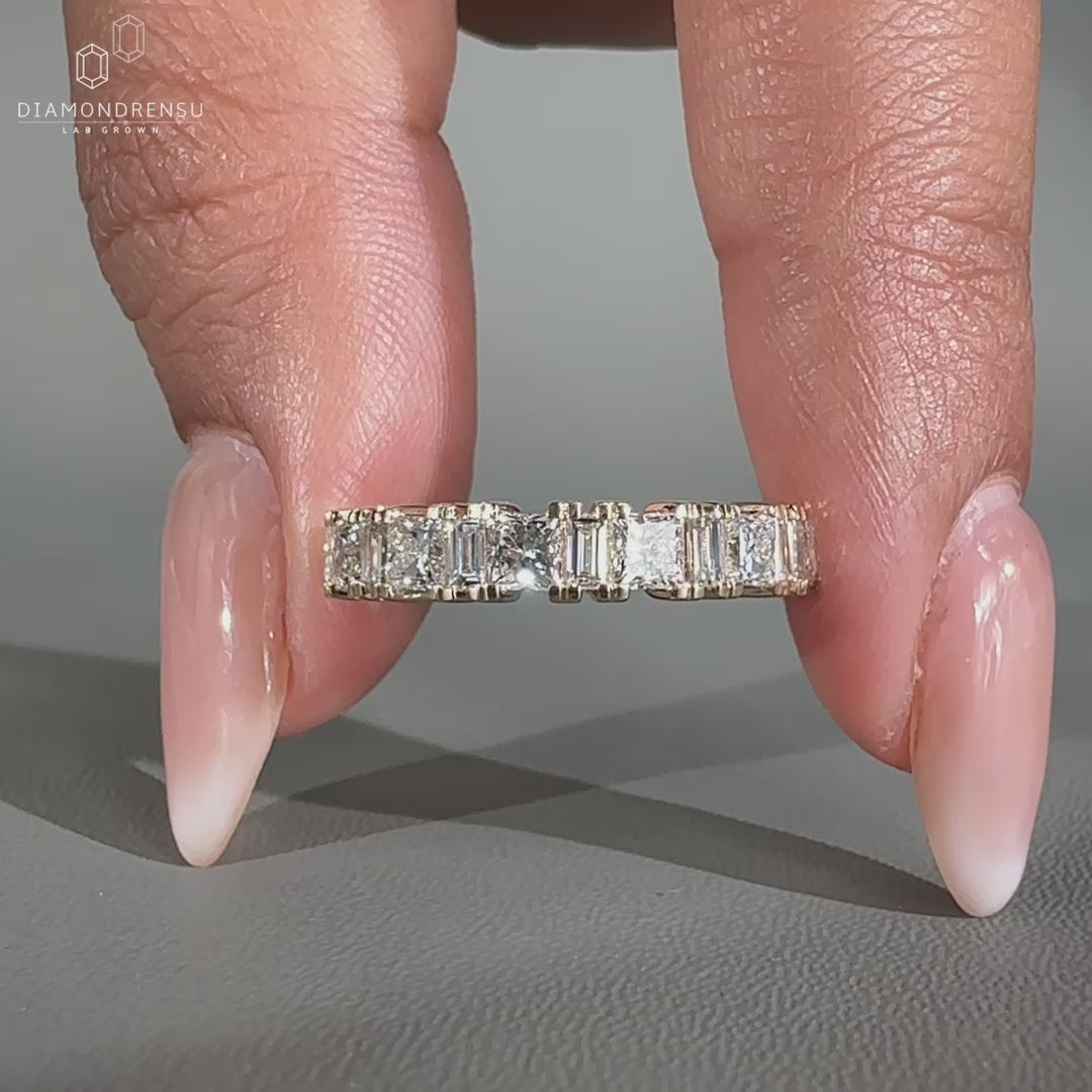 Half eternity wedding band featuring lab grown diamonds in prong settings.