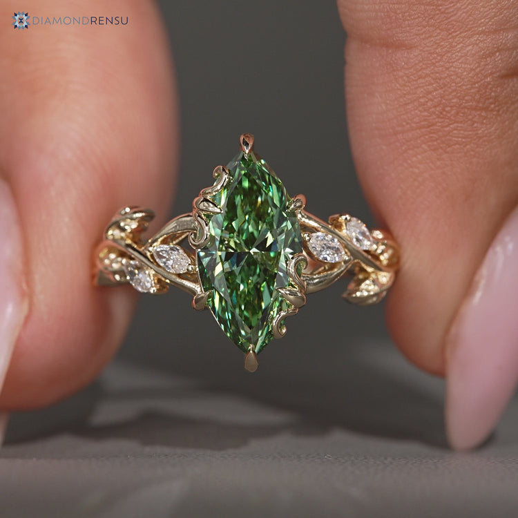 Green centre diamond ring with marquise side stone.