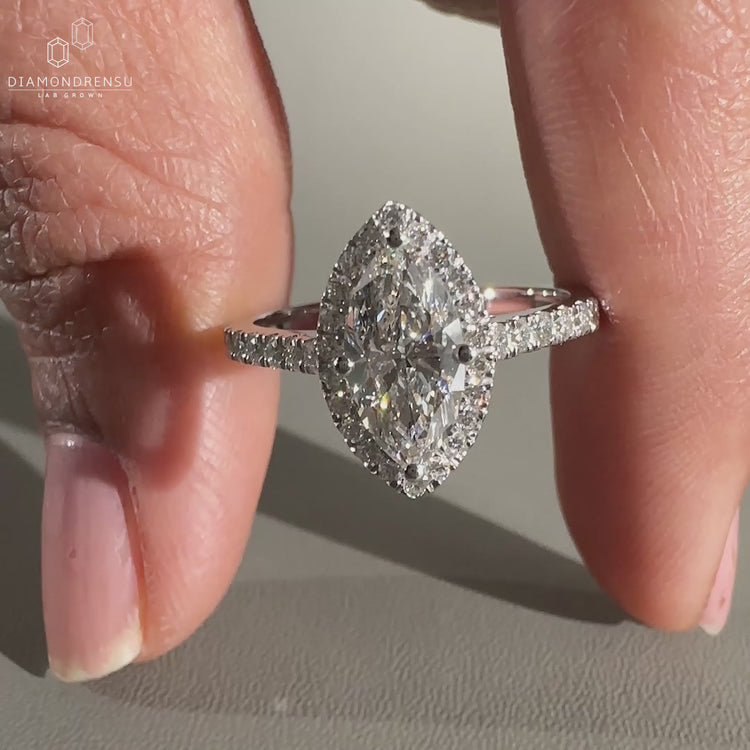 Marquise diamond ring with halo and pave details.
