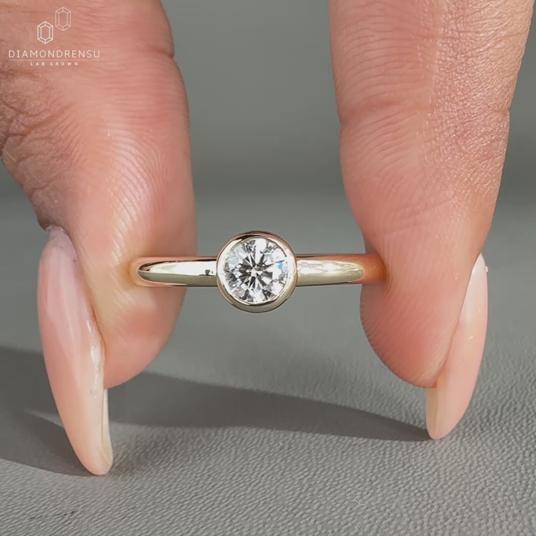 Bezel diamond ring crafted in yellow gold engagement ring style.
