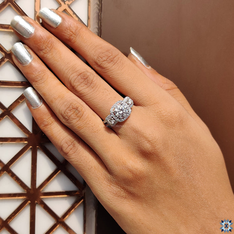 White gold engagement ring with halo and side stones.
