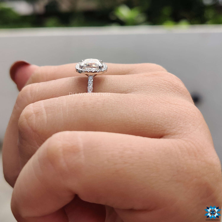 White gold engagement ring with moissanite and a halo pave design.
