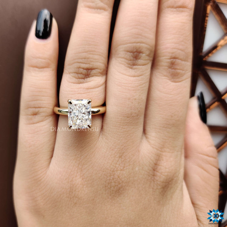 Handmade yellow gold ring featuring a radiant cut center stone.
