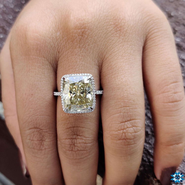 Light yellow cushion moissanite ring with halo setting.
