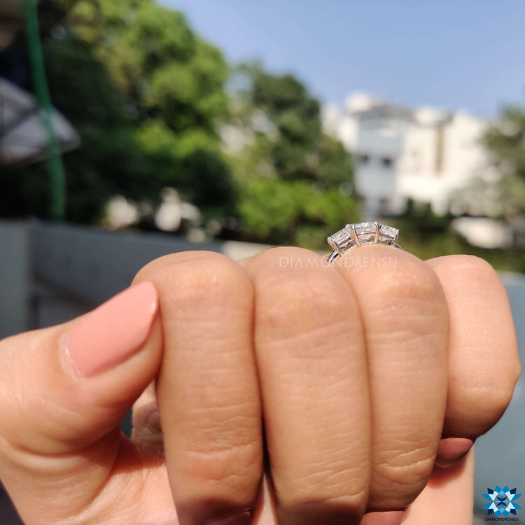 White gold prong set ring with emerald moissanite stones.
