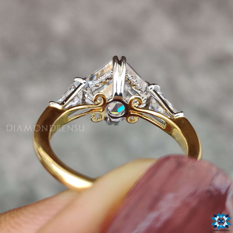 Moissanite ring with prong setting and two-tone band.
