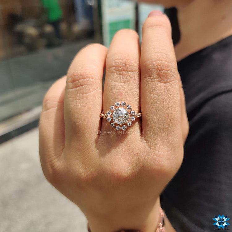 Round engagement ring with side stones in rose gold.

