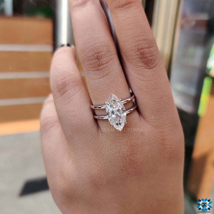 White gold solitaire ring featuring a marquise cut moissanite.
