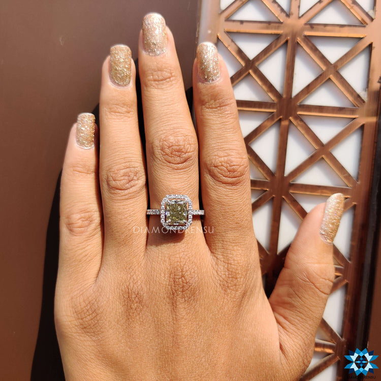 4 prong claw setting securing radiant greenish yellow moissanite in halo design.
