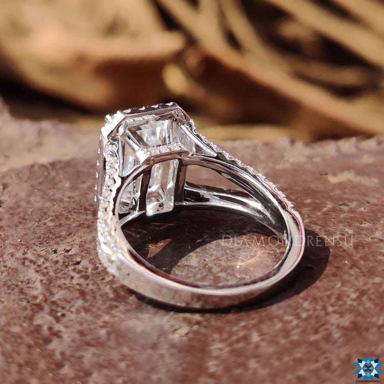Handmade engagement ring with emerald cut center stone.
