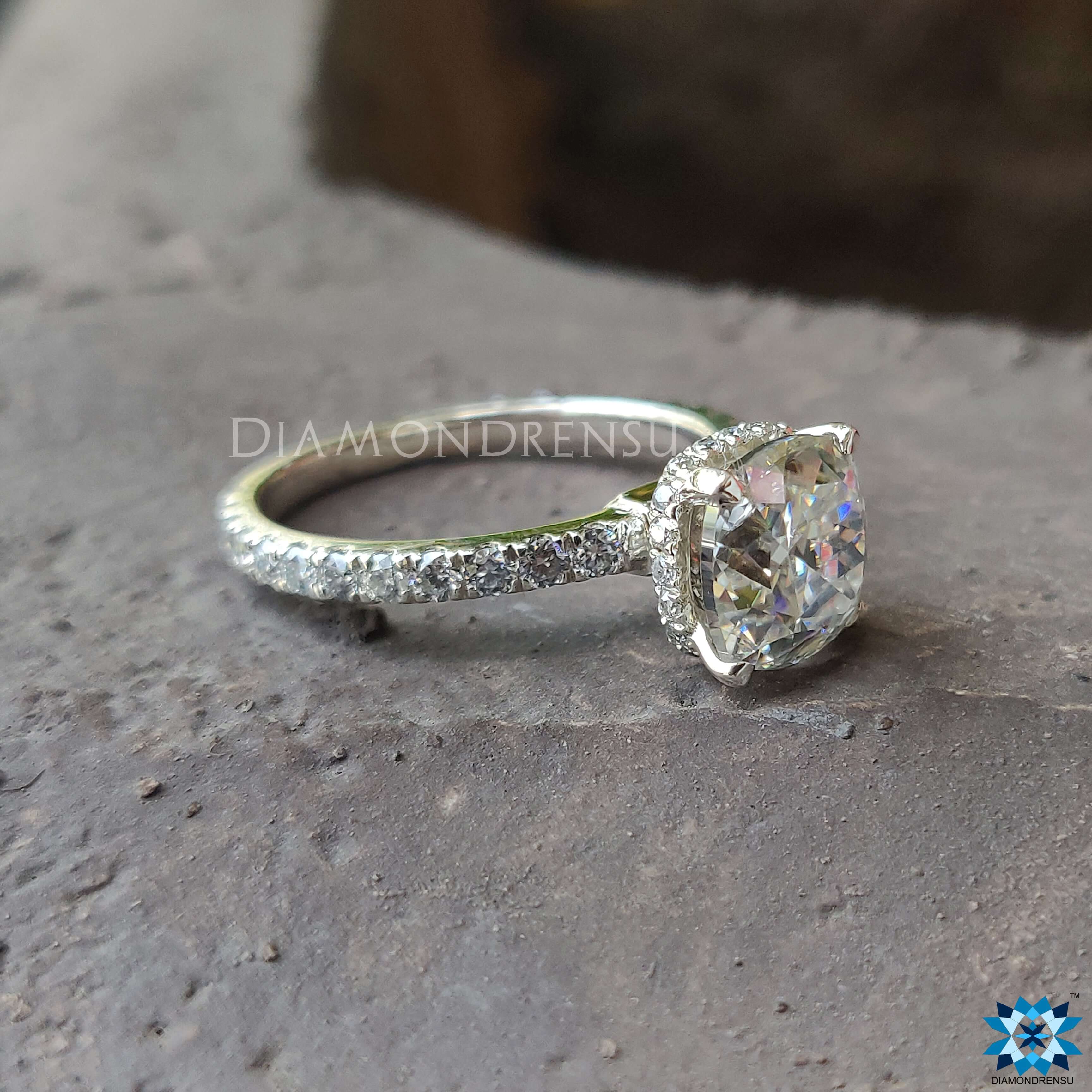 Moissanite pave ring featuring a cushion cut engagement ring in a prong setting.