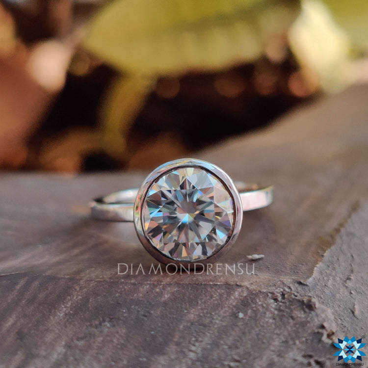 Round Moissanite bezel ring handcrafted in white gold for a timeless look.
