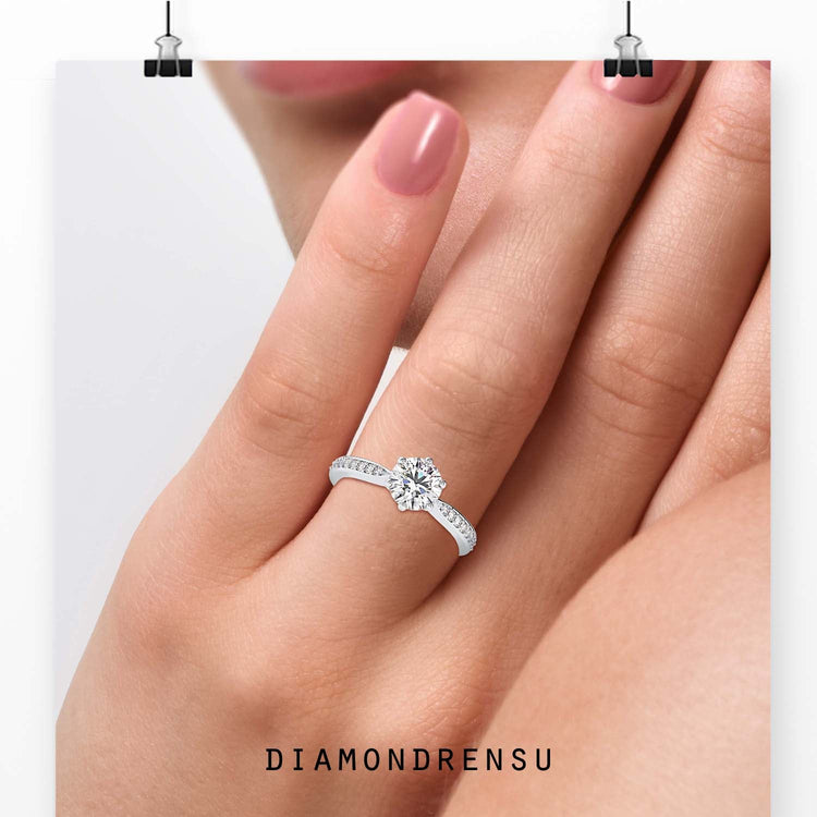 Round cut diamond ring with tapered pave band in white gold.
