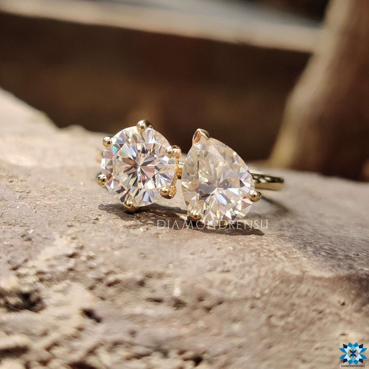 Round and pear moissanite ring in side-by-side style.
