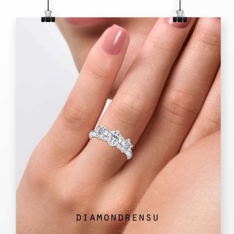 3 stone round diamond ring with six prong centre in white gold.
