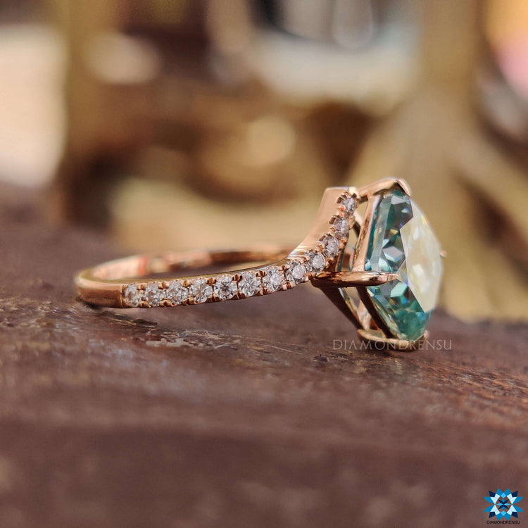 Rose gold ring with cushion cut center and round brilliant accents.
