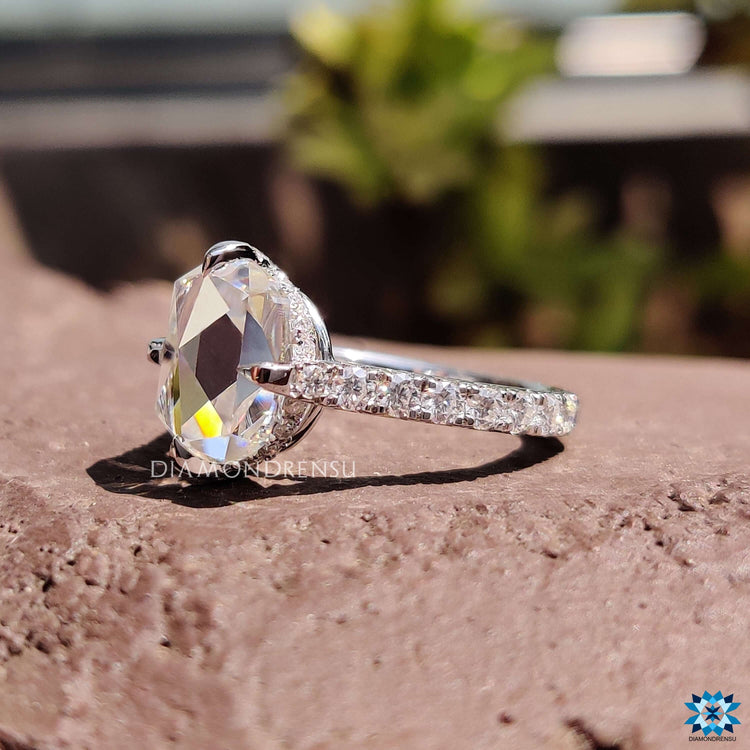White gold engagement ring with cushion moissanite center.
