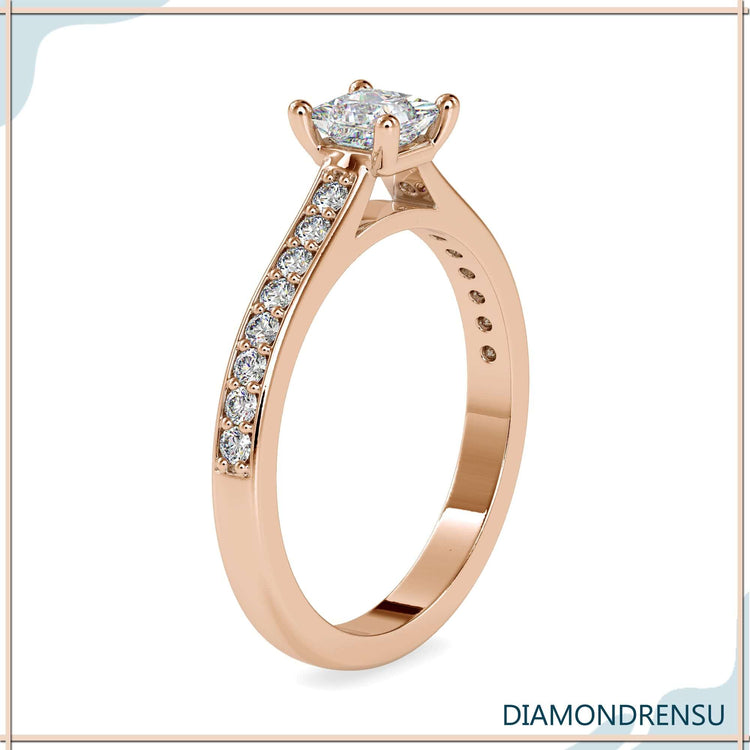 Round cut side stones in a rose gold engagement ring.
