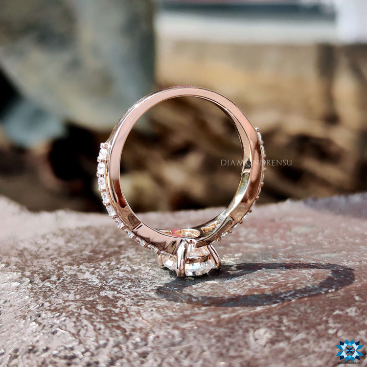 Oval twist engagement ring with pave round cut band.
