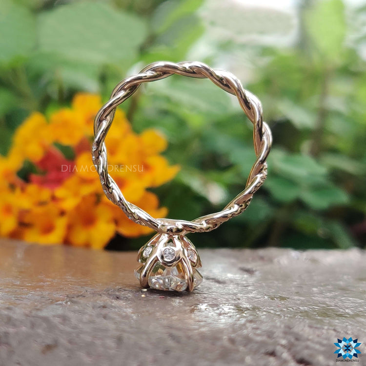 Custom engagement ring in rose gold with oval moissanite and round accents.
