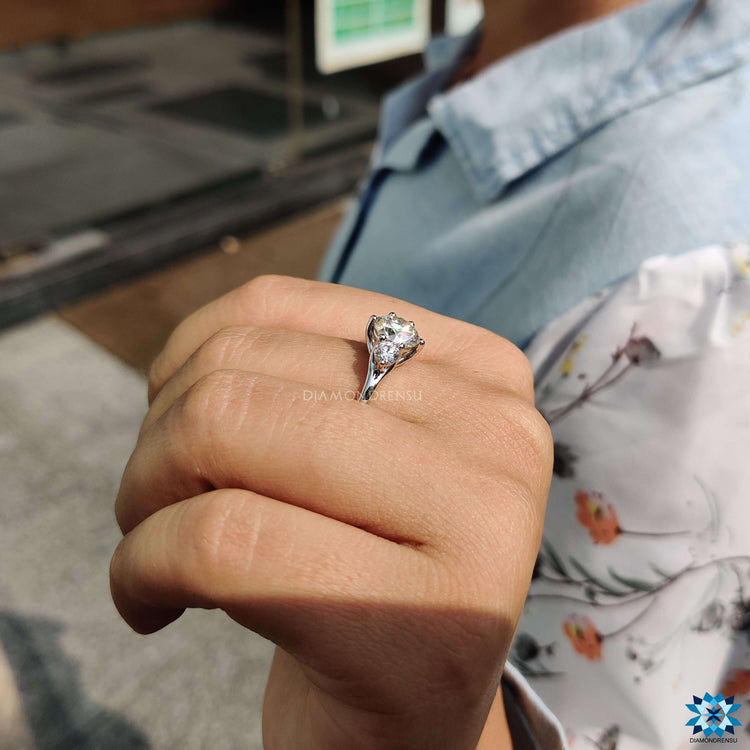 White gold prong setting ring featuring three moissanite stones.
