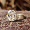 Hidden halo oval engagement ring in white and yellow gold band.
