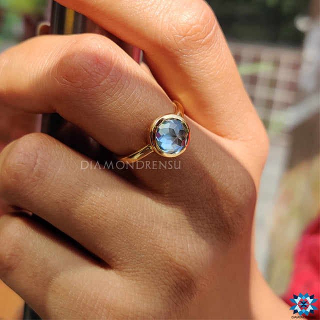 UK engagement ring in yellow gold with aqua rose cut stone.
