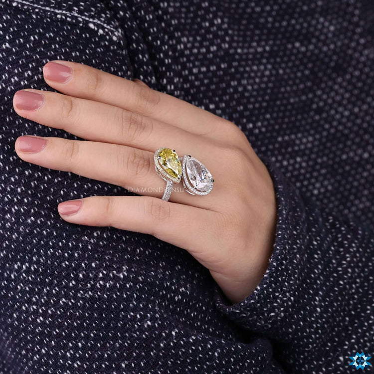Canary yellow pear moissanite ring with round cut halo accent stone.
