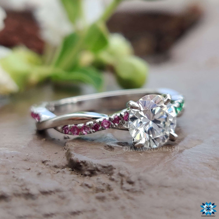 Handmade ring with moissanite center and ruby emerald side stones.
