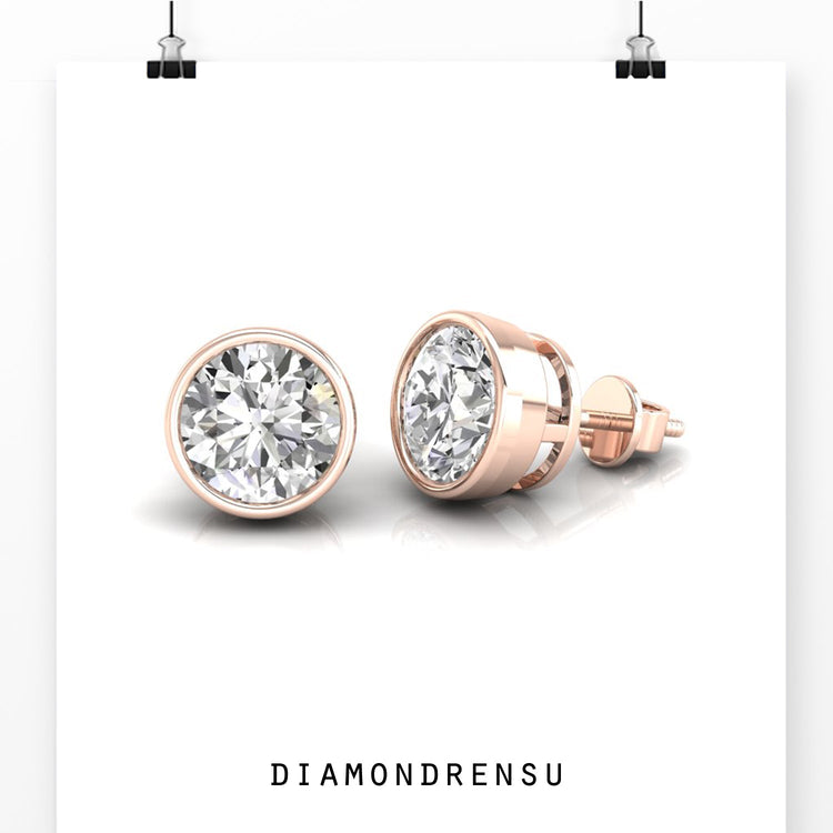 UK diamond earrings featuring round bezel set diamonds in white gold.
