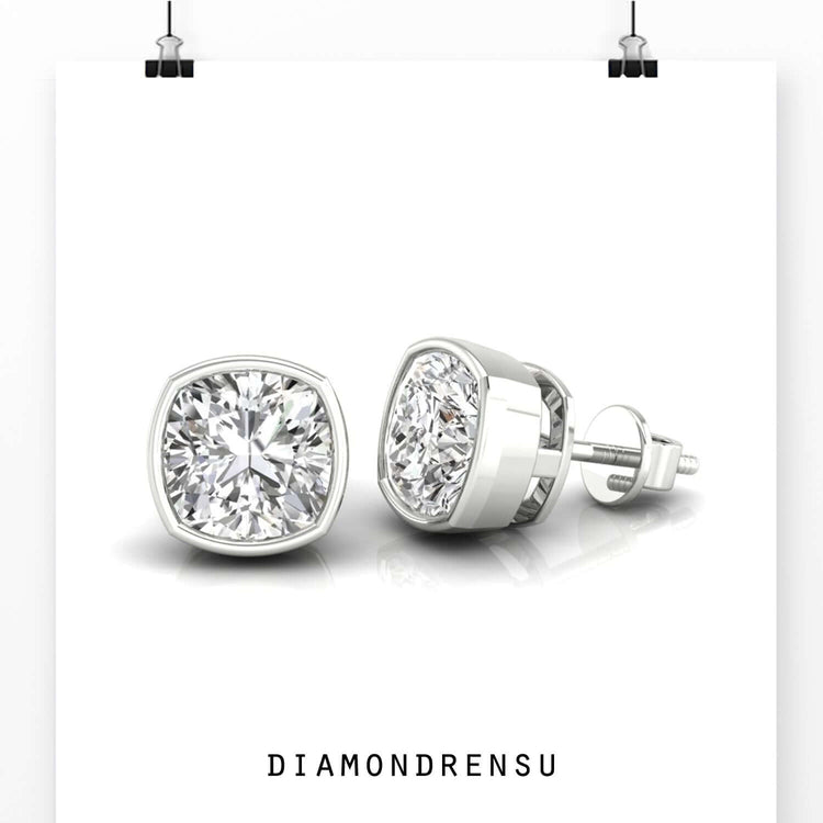 Diamond stud earrings in cushion bezel setting.
