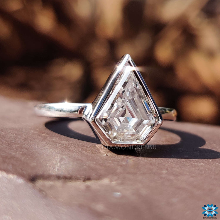 Custom engagement ring featuring bezel solitaire design.
