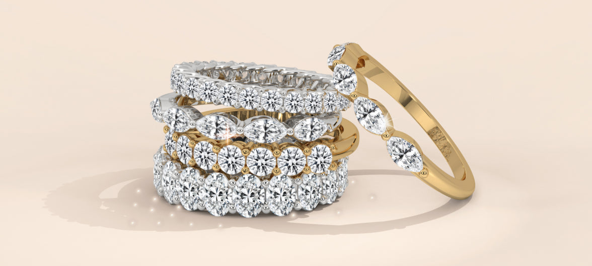 Stack of diamond eternity bands in white and yellow gold, featuring round and marquise cut stones.