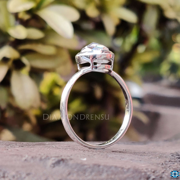 Moissanite solitaire ring in white gold with bezel setting and rose cut center stone.

