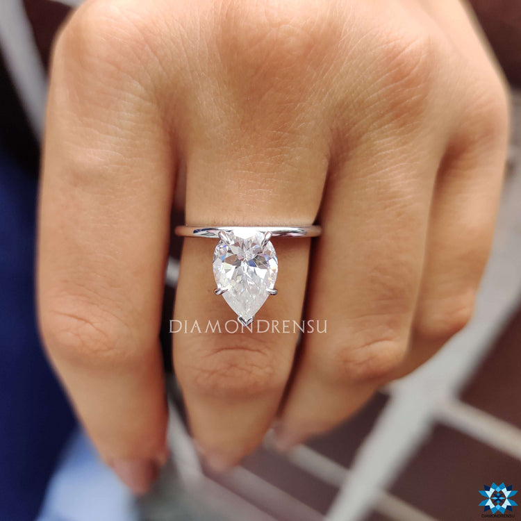 Handmade ring in white gold with prong setting and custom pear Rensu moissanite.

