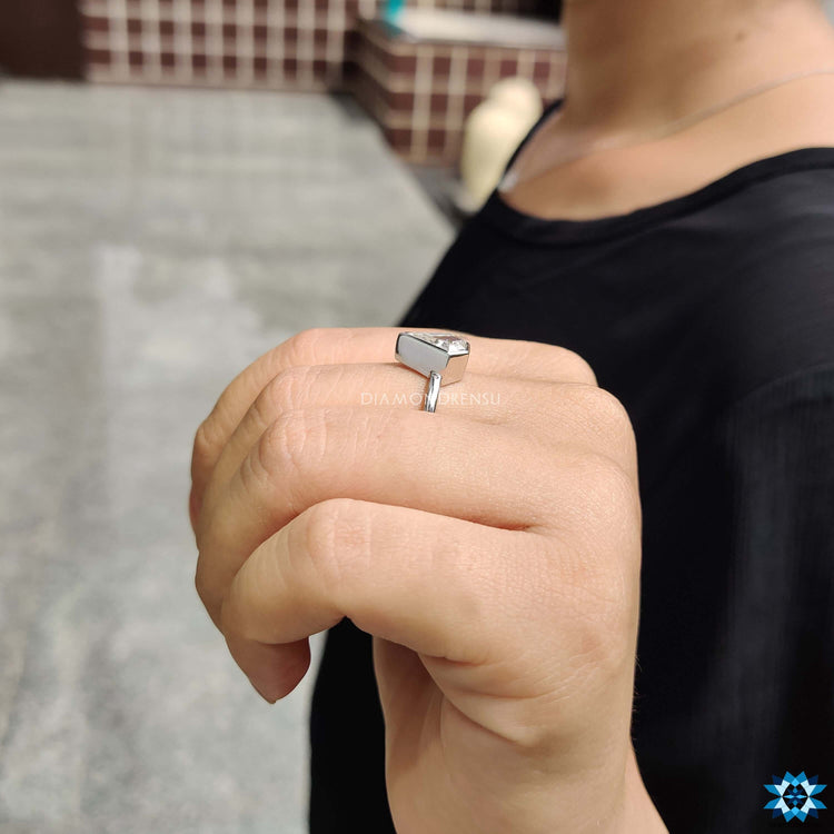 Moissanite solitaire ring with clean bezel frame.
