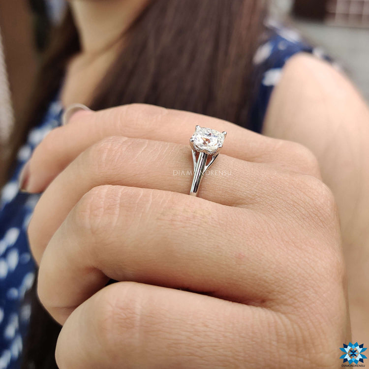 Prong setting moissanite ring with cushion cut center in a clean solitaire style.
