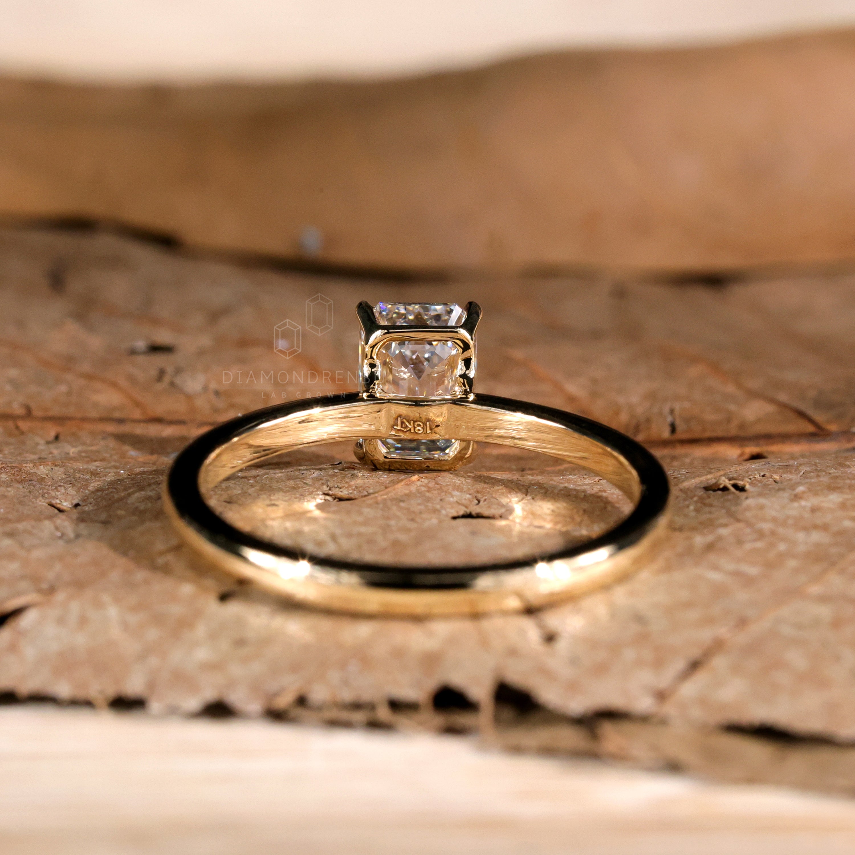 Gold emerald cut engagement ring with modern charm.